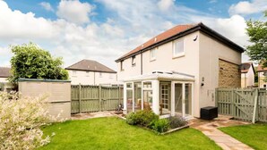 A two-story house with a conservatory, a fenced backyard, and a garage. - Modern Family House | Sleeps 5 | Free Parking - Pass the Keys (Edinburgh)