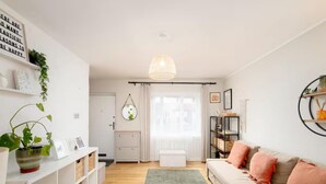 A modern living room with a sofa, a white console table, a green rug, and a pendant light. - Modern Family House | Sleeps 5 | Free Parking - Pass the Keys (Edinburgh)