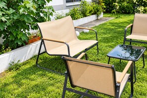 Ein Sitzbereich im Freien mit Tisch und zwei Stühlen.