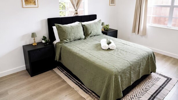 A bedroom with a bed, nightstands, a window with curtains, and a rug. - Near Hard Rock . Game Room + 15 Min to Beach (Hollywood)