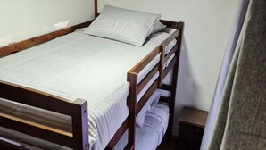 Een stapelbed met hoofdbord, nachtkastje en een vloerkleed met zebraprint.