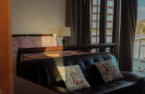 A hotel room with a bed, a sofa, and a window with curtains. - Casa Alegre 5-bedroom 5 Bath Luxury home stunning ocean view awaits your retreat (San Juan Del Sur)
