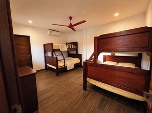 A room with two bunk beds, a ceiling fan, and an air conditioning unit. - Casa Alegre 5-bedroom 5 Bath Luxury home stunning ocean view awaits your retreat (San Juan Del Sur)