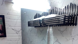 A bathroom with a white sink, a mirror, and a black towel rack. - G.BlissHomes | Stylish Modern Studio Near Nairobi CBD with King Bed & Work space (Nairobi)