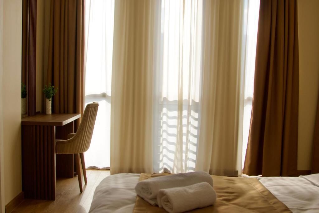 A hotel room with a bed, a desk, and a chair.