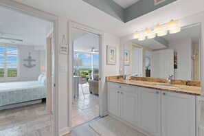 A modern bathroom with a large mirror, a sink, and a shower area.