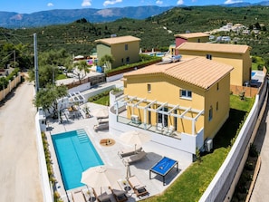 A residential area with a swimming pool, outdoor seating, and a view of the surrounding hills. - Kaletzia Villa IV - Four Bedroom Villa, Sleeps 8 (Zakinthos)