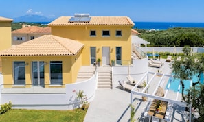 A yellow villa with a swimming pool, a covered outdoor seating area, and a view of the sea. - Kaletzia Villa IV - Four Bedroom Villa, Sleeps 8 (Zakinthos)