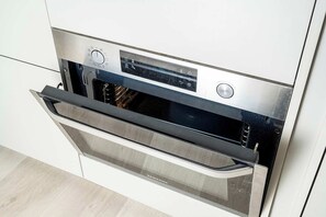 Eine moderne Küche mit Backofen, Edelstahlfront und digitaler Bedienkonsole.