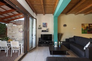 Ein offener Wohnbereich mit Fernseher, Sofa und Esstisch.