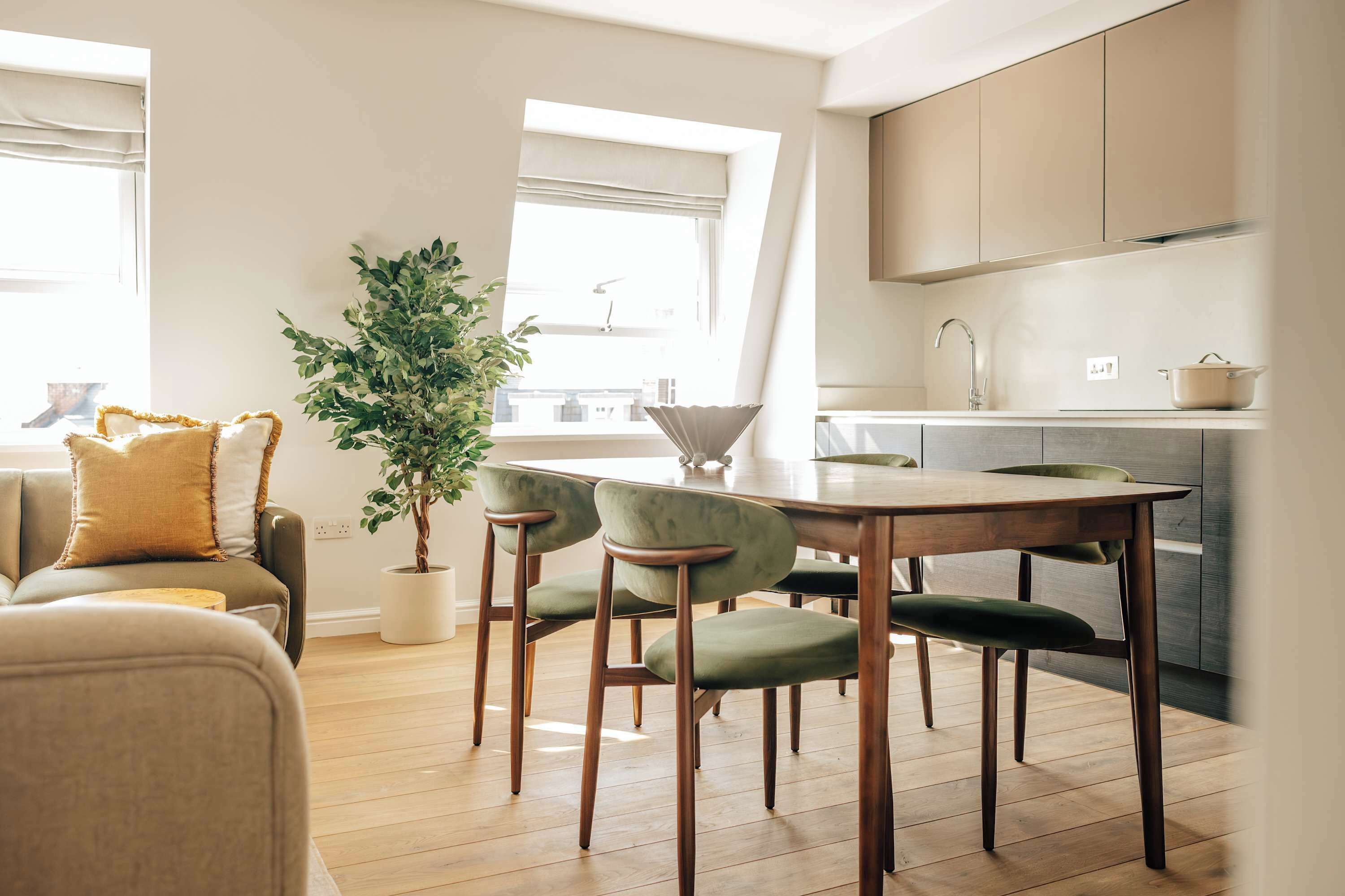 Eine moderne Küche mit Holzausstattung, einer Spüle und einem Essbereich mit Tisch und Stühlen.