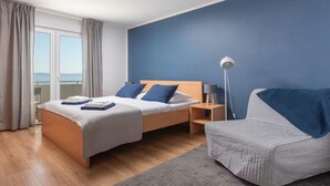 Ein Schlafzimmer mit Bett, Nachttisch, Lampe und einem Sessel.