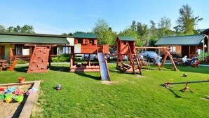 A playground with a slide, swings, and climbing structures. - Holiday home with a terrace, close to the sea (Sianozety)