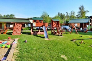 A playground with a slide, swings, and climbing structures. - Holiday home with a terrace, close to the sea (Sianozety)