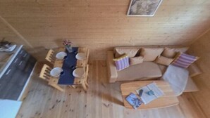 A wooden interior with a dining table and chairs, a sofa, and a small coffee table. - Holiday home with a terrace, close to the sea (Sianozety)