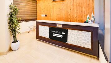A reception desk with a wooden panel wall, a clock, and a reception sign.