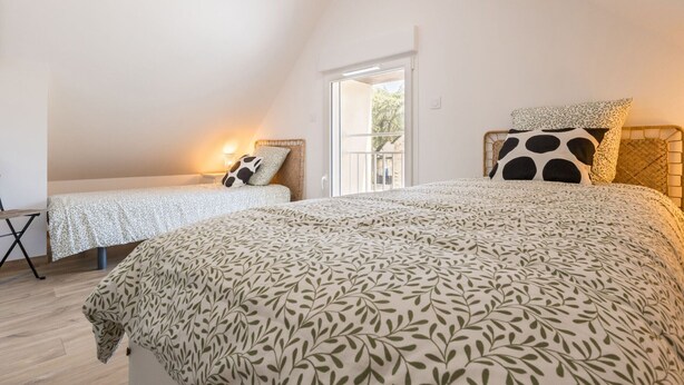 A bedroom with two beds, a balcony, and a view of the outdoors. - Peaceful country cottage - 6 guests (Nort-sur-Erdre)