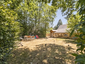 A stone building with a sloped roof, surrounded by trees and a grassy yard. - Peaceful country cottage - 6 guests (Nort-sur-Erdre)