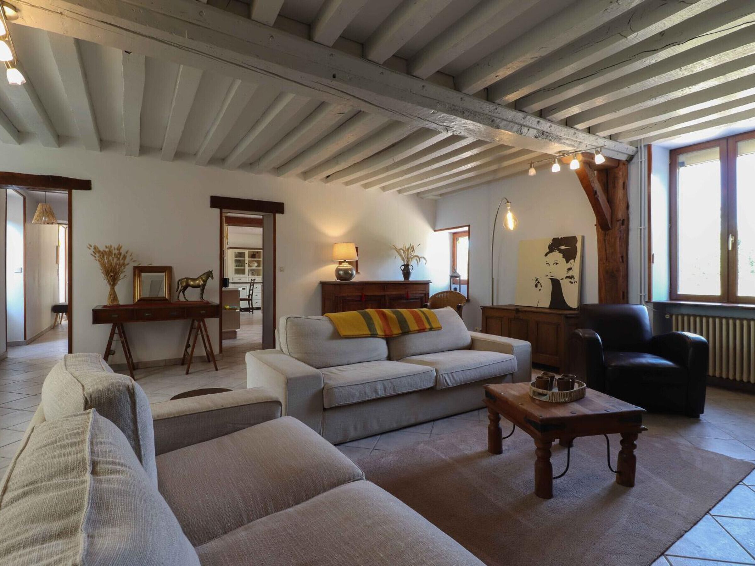 A spacious living room with a high ceiling, a sofa set, a coffee table, and a fireplace.