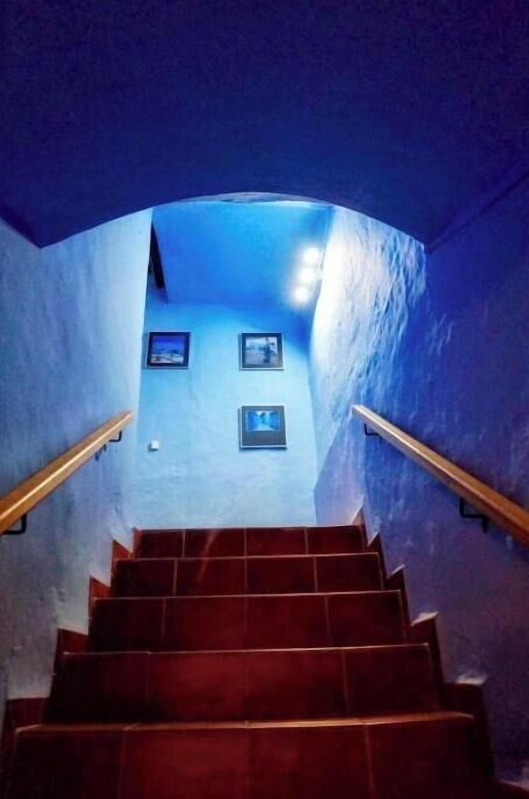 Eine Treppe mit einer gewölbten Wand und gerahmten Bildern.