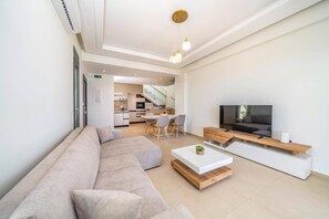 Ein modernes Wohnzimmer mit einer Couch, einem Couchtisch und einem Fernseher.