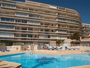 A multi-story hotel with a swimming pool and sun loungers. - Lovely air-conditioned apartment - 4 guests, mountain view (Canet-en-Roussillon)