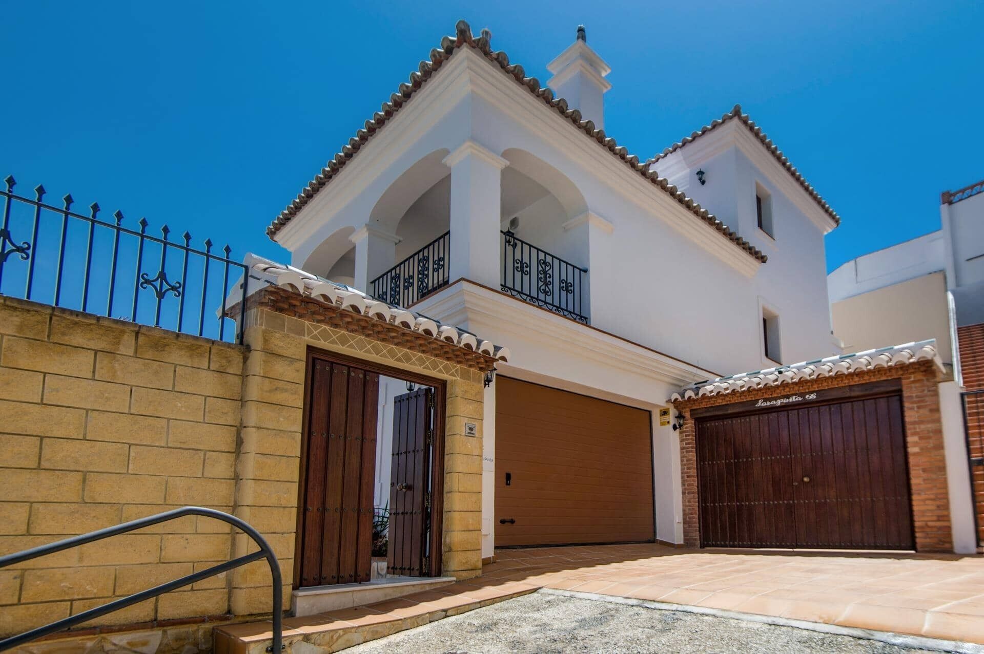 Ein zweigeschossiges Haus mit Balkon, Garage und einem abschließbaren Eingang.
