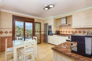 Eine Küche mit Aussicht, ausgestattet mit Kühlschrank, Backofen, Mikrowelle und Kaffeemaschine.