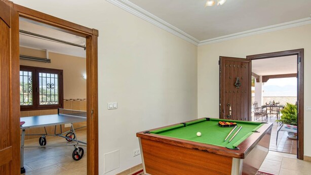 A pool table in a room with a view of a balcony. - Villa Lara Pinta by Villa Plus (Nerja)