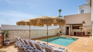 A pool area with lounge chairs and a bar. - Villa Lara Pinta by Villa Plus (Nerja)