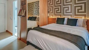 A hotel room with a bed, a wardrobe, and a mirror. - Fully furnished apartment with TV and free internet. (São Paulo)
