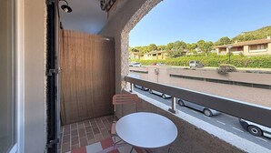 A balcony with a view of a road, a parked car, and residential buildings. - Studio with AC and terrace - 4 guests (Saint-Cyr-sur-Mer)