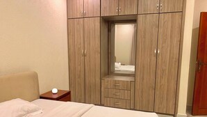Una camera da letto con un letto, un comodino, un armadio e uno specchio.