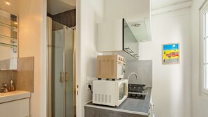 Een kleine keuken met een magnetron, broodrooster en spoelbak.