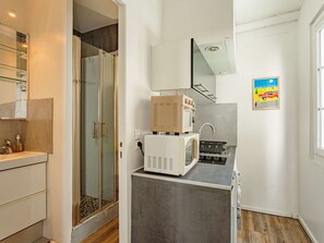 Eine kleine Küche mit Mikrowelle, Toaster und Spüle.
