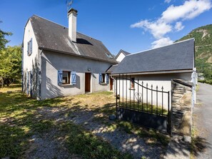 A two-story house with a stone foundation, a metal gate, and a clear sky. - Large house, pets allowed - 10 guests (Vielle-Aure)
