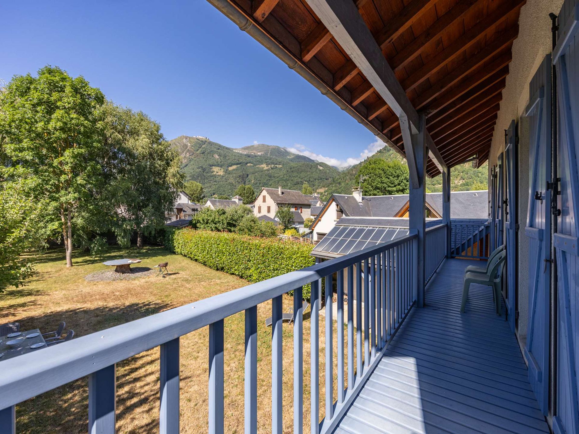 Un balcon avec vue sur une montagne, un plafond en bois et une balustrade.