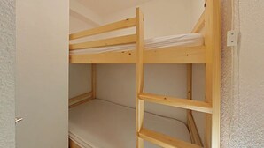 Un letto a castello con struttura in legno e materasso.