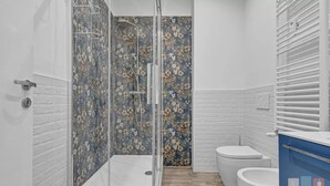 Ein Badezimmer mit Dusche, Toilette und Waschtisch.