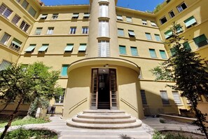 Un edificio de varios pisos con una escalera central que lleva a una entrada.