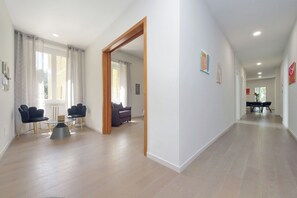 Un espacio habitable amplio con un sofá, una mesa de comedor y una cocina al fondo.
