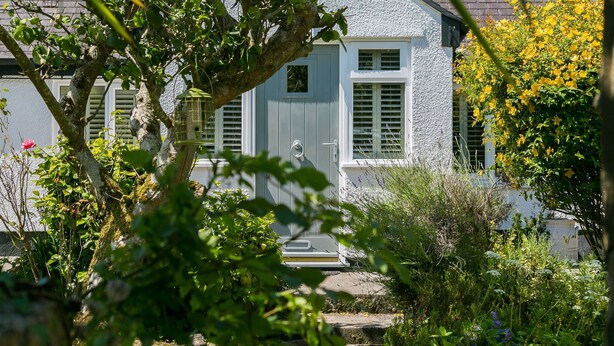 A house with a grey exterior, white shutters, and a front door. - Penrallt - sleeps 8 guests  in 4 bedrooms (Benllech)