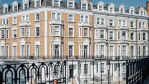 A row of terraced houses with uniform architecture, white window frames, and a black metal fence in the foreground. - The Knaresborough -Stylish Earl's Court Apartment (London)
