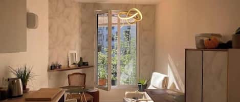Cocina compacta con comedor, ventana con vistas y una lámpara colgante moderna.