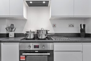 Eine moderne Küche mit Edelstahlgeräten, einem Backofen und einer Dunstabzugshaube.