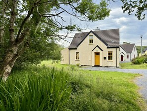 Une maison à deux étages, dotée d’un toit en pente, d’une entrée principale et d’une cheminée bien visible.