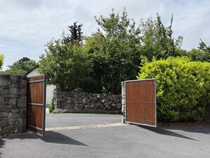 Een hek met een stenen muur en een metalen poort.