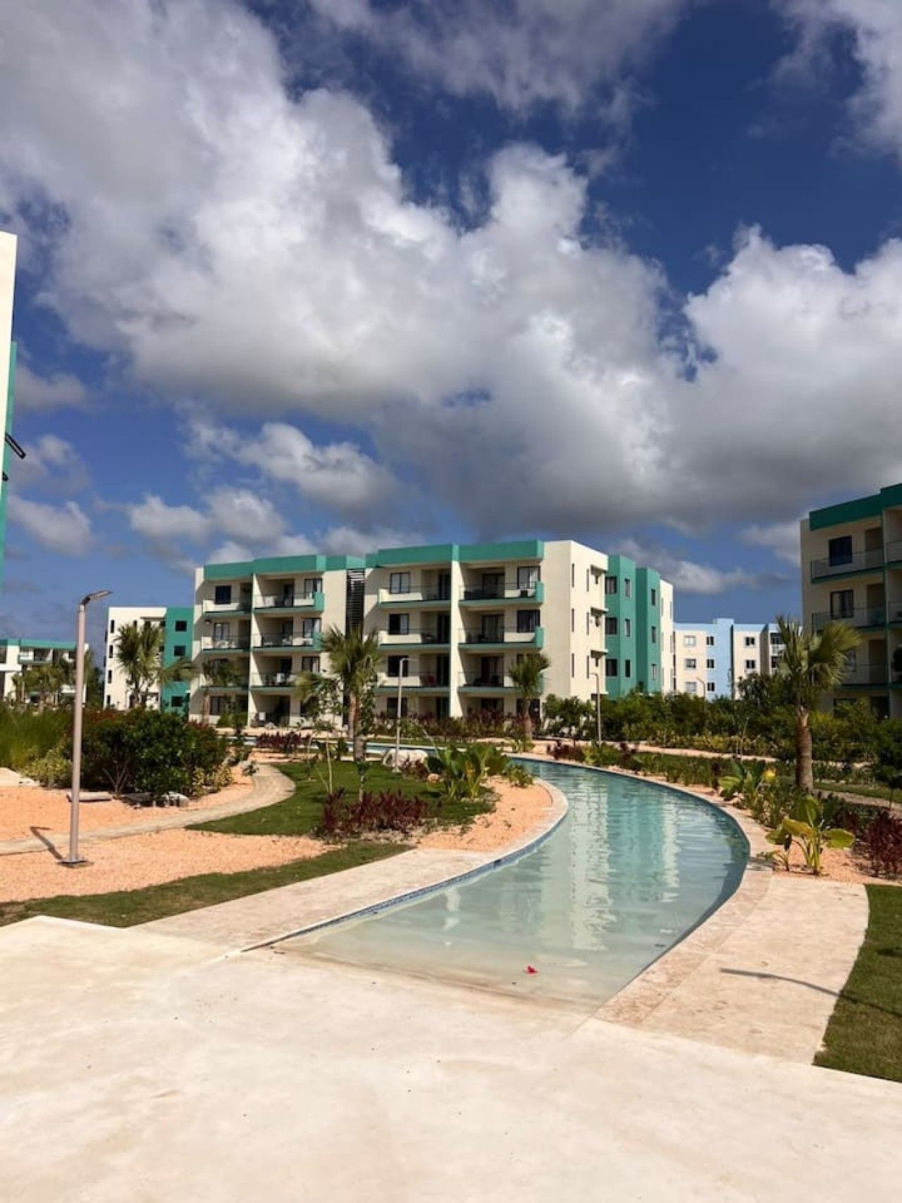 Ein Resort mit Schwimmbad, mehrstöckigen Gebäuden und blauem Himmel.