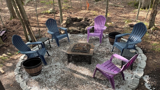 A circular seating arrangement with Adirondack chairs and a fire pit in the center, surrounded by a gravel border. - Shady Leaf Lodge - Family and pet-friendly! Arrowhead Lake getaway (Pocono Lake)