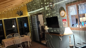 A cozy room with a foosball table, a television, and a dining area with chairs and a table. - Shady Leaf Lodge - Family and pet-friendly! Arrowhead Lake getaway (Pocono Lake)